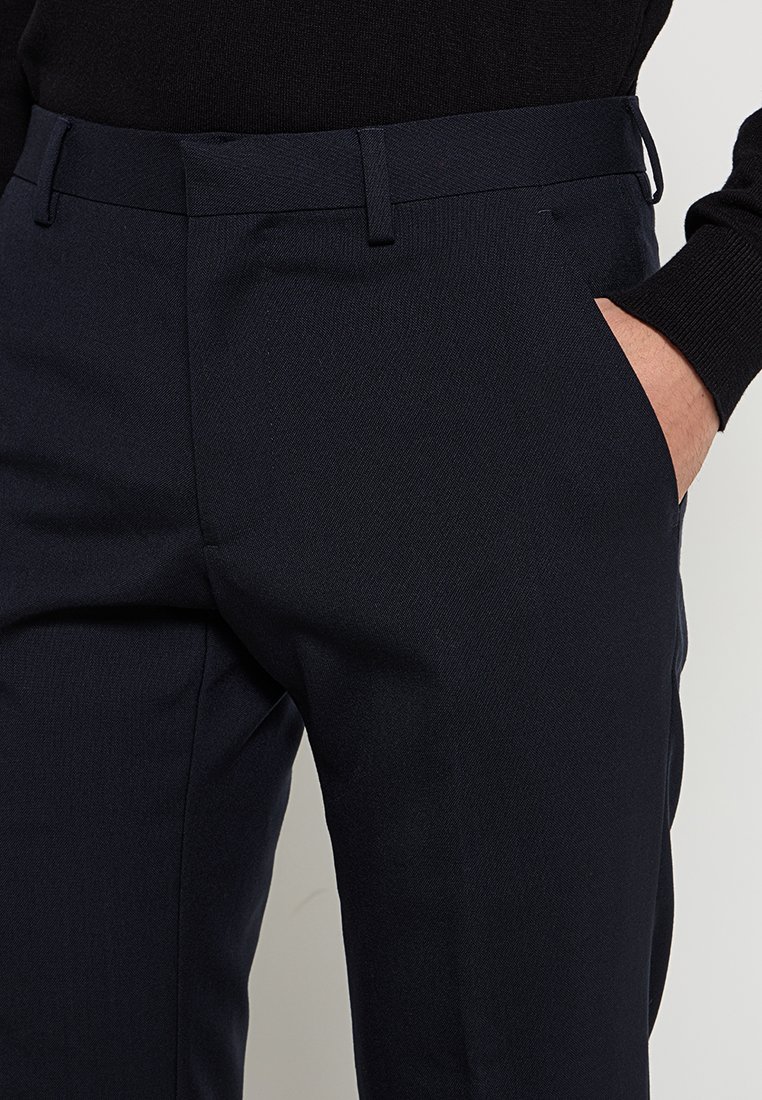 Pantalones de corte recto en tejido texturizado de color marino, con bolsillos laterales y una cintura plana para un diseño estilizado.