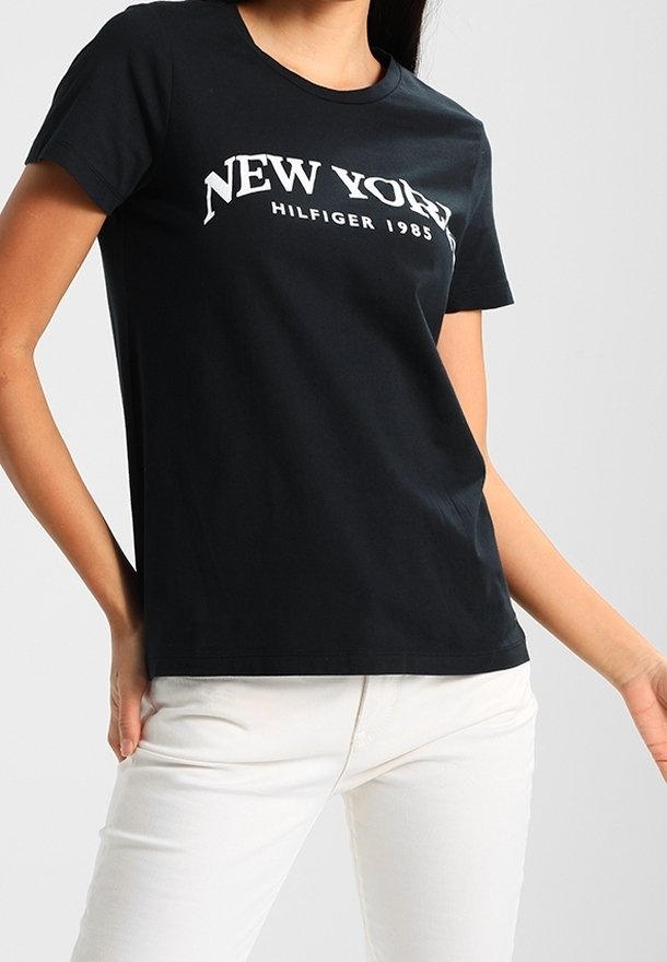 Černé bavlněné tričko s bílým nápisem "NEW YORK HILFIGER 1985". Krátké rukávy, kulatý výstřih a klasický střih.