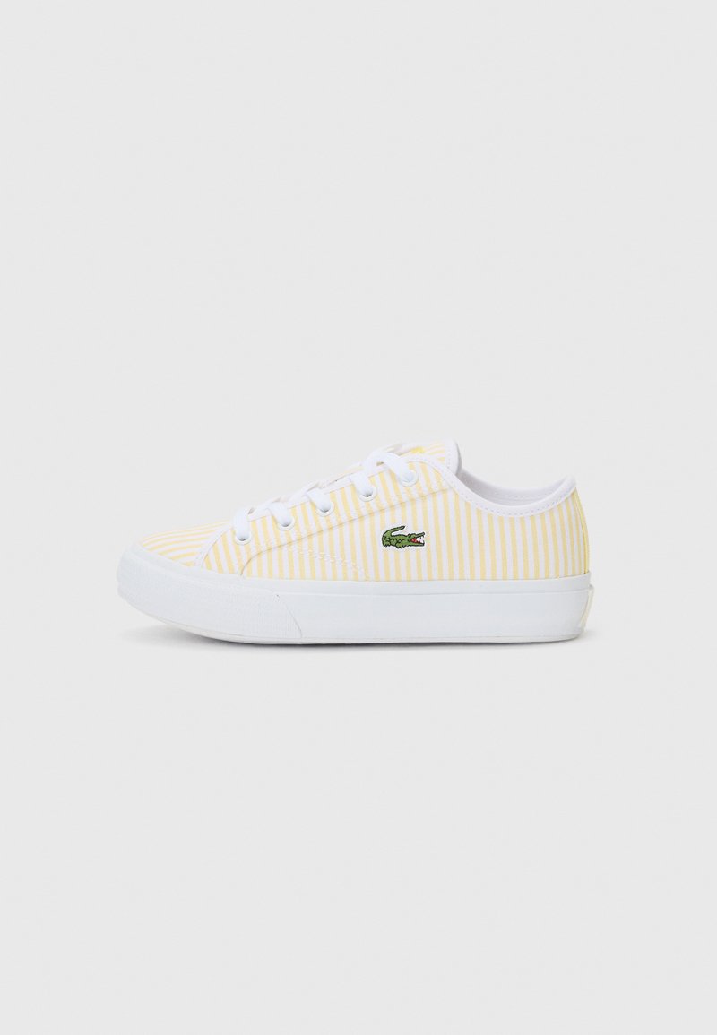 Gule og hvite stripete lerrets sneakers med hvit gummisåle og lufthull, med en liten grønn brodert logo.