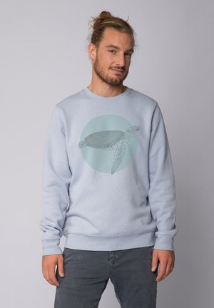 Lichtblauwe sweatshirt met een ronde afbeelding van een zeeschildpad in het groen. Gemaakt van zacht materiaal, heeft lange mouwen en geribbelde manchetten.