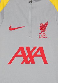Graues langärmeliges Sportoberteil mit gelben Akzenten, featuring rotem Nike-Logo, Liverpool FC-Wappen und einem übergroßen roten AXA-Logo.