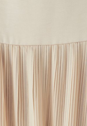 Pleated skirt featuring a smooth, beige waistband and flowing, textured fabric with delicate vertical pleats in a lighter shade of cream.