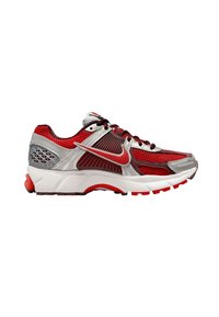 Röd och silver atletisk sko med nätövre, gummisula, distinkta geometriska detaljer och röda snörningar. Har Nike-logotypen på sidan.