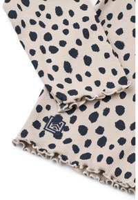 Ριμπ πουλόβερ σε μπεζ με σχέδιο με λευκά και μπλε στίγματα. Διαθέτει ξεφτισμένα τελειώματα και ταμπέλα με γεωμετρικό μοτίβο. Μαλακή υφή.