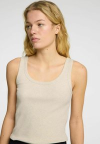 Beige geribbelde tanktop met een brede halslijn en mouwloos ontwerp, met een gladde textuur en een aansluitende pasvorm.