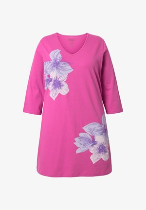 Tunic rosa a maniche lunghe con scollo a V, caratterizzata da grandi stampe floreali viola e bianche sulla parte superiore sinistra del petto e sul lato destro inferiore.