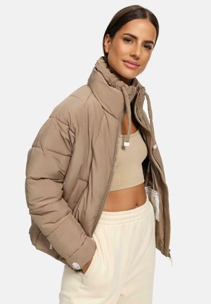 Khaki pufferjack met hoge kraag, ritsluiting en trekkoorden. Beschikt over een gestikte textuur en zijzakken, gelaagd over een beige cropped top.