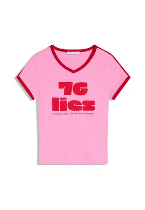 Rózsaszín V-nyakú póló piros szegéllyel az ujjain és a gallérnál, vastag piros felirattal: "76 hazugság" és alatta kisebb, dőlt motivációs szövegek.