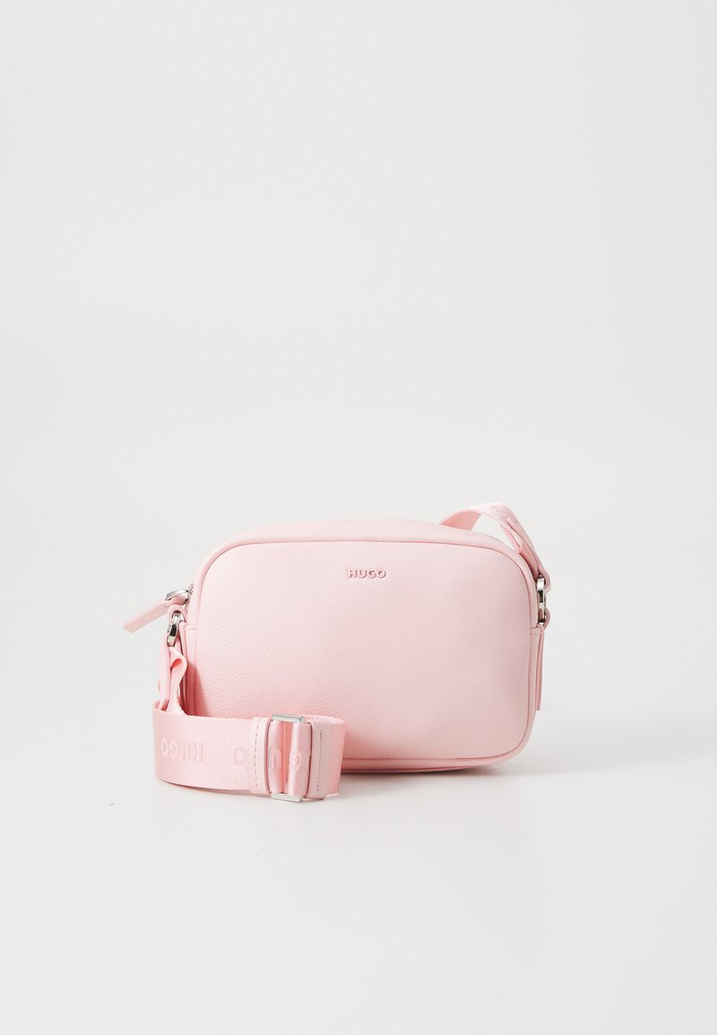 Ružová syntetická crossbody taška s textúrovaným povrchom, obdĺžnikovým tvarom, zipsovým uzáverom a nastaviteľným popruhom s logom značky.