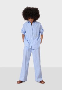 Blårandig skjorta och matchande byxor i lättviktsmaterial. Skjortan har knappstängning, krage och två fickor; avslappnad passform.