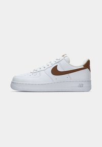 Bijela Nike Air Force 1 tenisica s smešnim swooshom i petnim trakama u smešnoj boji, prikazana sa vanjske strane na jednostavnoj bijeloj pozadini.