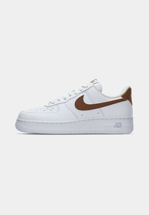 Weiße Nike Air Force 1 Sneaker mit braunem Swoosh und Fersentab, von der Außenseite auf einem schlichten weißen Hintergrund betrachtet.