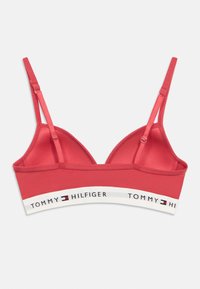 Κόκκινο αθλητικό σουτιέν με τριγωνικά cups, ρυθμιζόμενες τιράντες και λευκή ζώνη με το λογότυπο "TOMMY HILFIGER" σε μαύρες και κόκκινες λεπτομέρειες.
