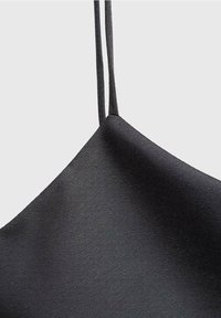 Camisole en satin noir avec fines bretelles, présentant une texture lisse et un design triangulaire. Style simple et minimaliste.