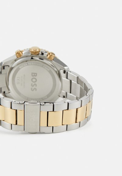 Montre en acier inoxydable argentée et dorée avec un bracelet à maillons multiples, fonctionnalités chronographe et boîtier rond. Conception résistante à l'eau.