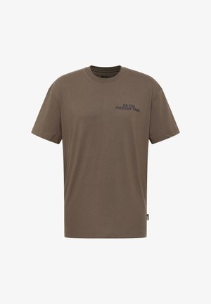 T-shirt en coton vert olive à manches courtes, col rond, avec "SUR LE CHEMIN DE LA LIBERTÉ" imprimé en bleu foncé sur le côté gauche de la poitrine.