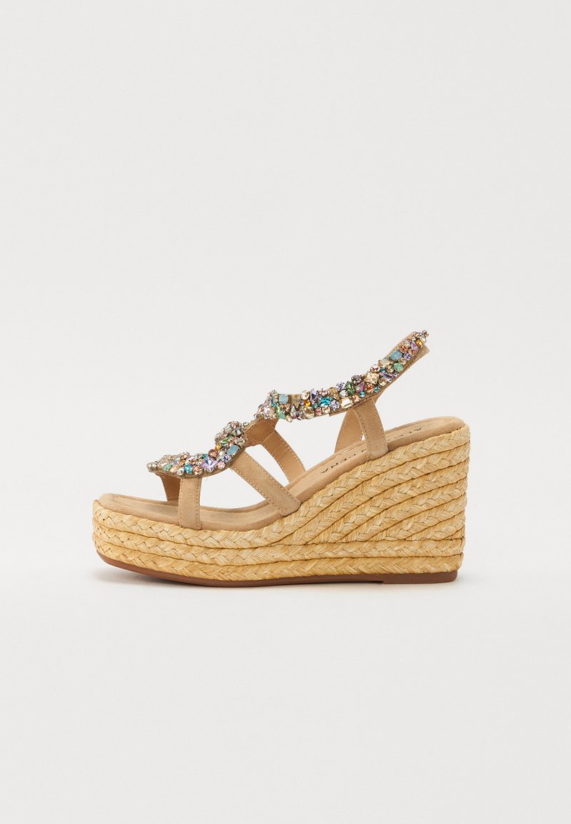 Krémové klínové sandály s tkanou juty podrážkou, dekorativními krystalovými akcenty a několika pásky. Hladký povrch s designem zaoblené špičky.