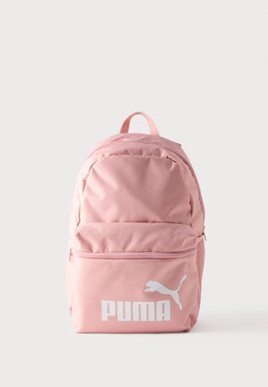 Ruksak od ružičaste tkanine s velikim prednjim džepom, podesivim naramenicama i bijelim logotipom Puma. Glatka tekstura i zaobljeni oblik.