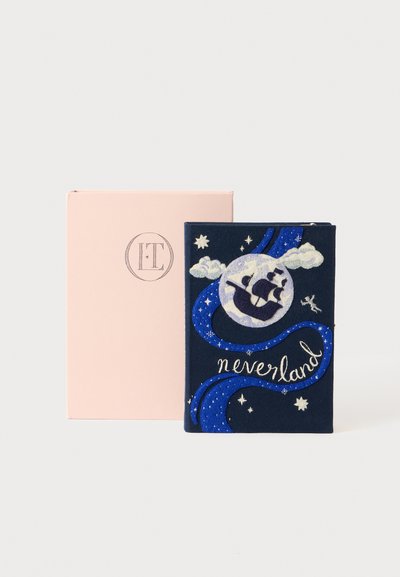 Tamsiai mėlynas audinio užrašų bloknotas su siuvinėtu dizainu, vaizduojančiu laivą, debesis ir mėnulį, pavadintas "niekurėn", padėtas šalia rožinės dėžutės.