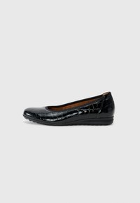 Ballerine en cuir verni noir avec un bout rond, motif crocodile et un petit talon compensé. Doublure intérieure marron et semelle flexible.