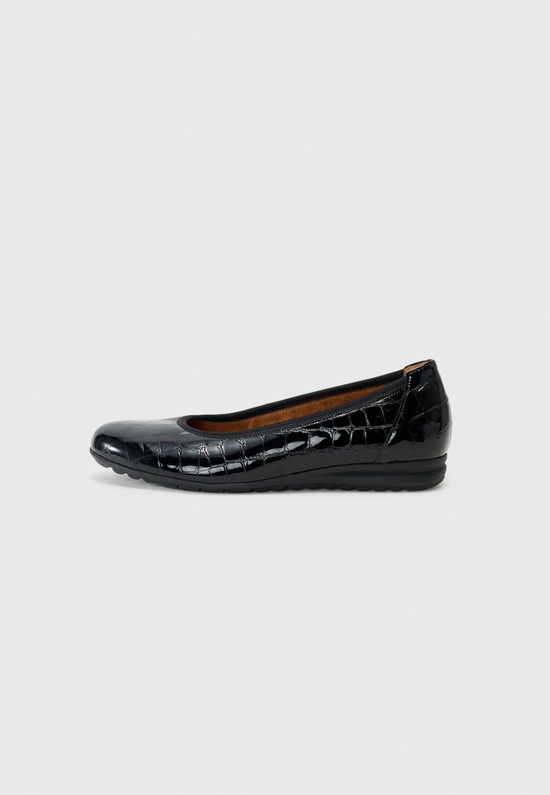Ballerine en cuir verni noir avec un bout rond, motif crocodile et un petit talon compensé. Doublure intérieure marron et semelle flexible.
