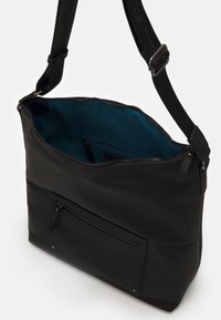 Borsa a spalla nera con tracolla regolabile, tasca frontale con zip e interno in tessuto teal che mostra una tasca interna con zip, apertura della zip superiore.