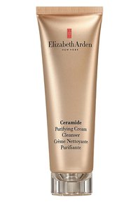 Złoty tubka z zakrętką z napisem "Ceramide Purifying Cream Cleanser" w czarnym kolorze oraz przezroczystą plastikową podstawą do dozowania.