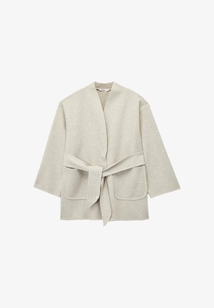 Lichtgrijze wikkeljas van zachte stof, met een strikceintuur, twee voorkruimelzakken en een eenvoudige, open ontwerp met wijde mouwen.