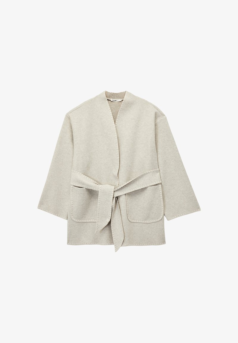 Chaqueta envolvente de color gris claro en tejido suave, con cinturón de lazo, dos bolsillos frontales y un diseño sencillo y abierto con mangas anchas.