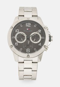 Silberne Edelstahl-Armbanduhr mit einem grauen strukturierten Zifferblatt. Verfügt über große Ziffern, Datumsfunktion und Chronographen-Unterdials.