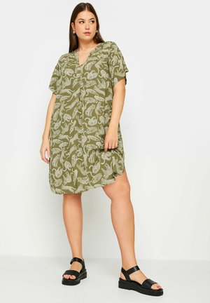 Groene jurk met korte mouwen en een v-hals, met een wit dierenprintmotief. De stof is lichtgewicht en vloeiend, wat zorgt voor een comfortabele pasvorm.