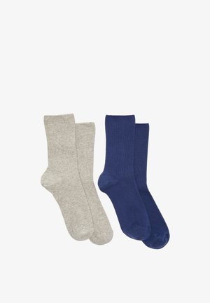 Deux paires de chaussettes basses unies, une gris clair et l'autre bleu foncé, posées côte à côte sur un fond blanc.