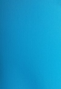 Jasně modrá látka s hladkým, texturovaným povrchem, která má jednobarevný vzhled bez viditelných vzorů nebo akcentů.