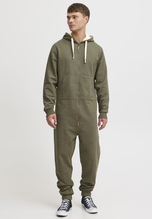 Oliven grøn lynlåsdragt lavet af blødt stof, med hætte, forlommer, ribbet manchetter og en kontrasterende beige snor.