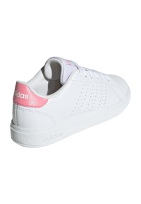 Zapatilla de cuero blanco con suela blanca texturizada, que presenta acentos rosa en el talón y lados perforados. Incluye cordones y lengüeta acolchada.