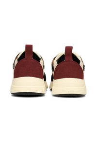 Scarpe sportive con una tomaia nera e beige chiaro, dettagli in suede bordeaux e una suola di crema testurizzata con un linguetta sul retro.
