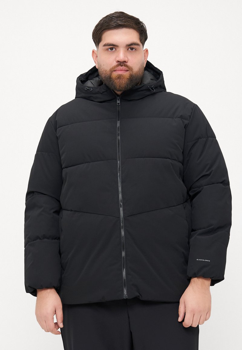 Black puffer jacket with a zip front, hood, and ribbed texture. Features horizontal panels and a discreet logo on the sleeve.