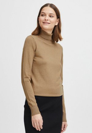 Maglione collo alto marrone in materiale a maglia fine, design aderente con maniche lunghe e polsini a costine, abbinato a una gonna nera a costine.