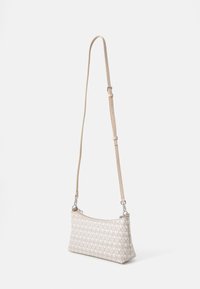 Sac bandoulière beige en cuir à motifs, avec une forme élancée, une bandoulière ajustable et des finitions en métal argenté avec une fermeture éclair.