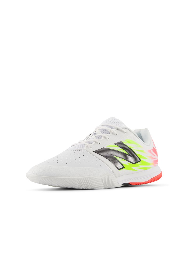 Zapato deportivo blanco con parte superior perforada, acentos en negro y verde neón, y una suela texturizada. Presenta un vibrante degradado de color en los laterales.