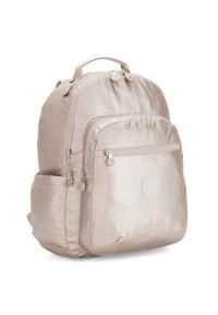 Lichtbeige rugzak van nylon, met een ronde vorm, ritszakken en een cirkelvormig logodetail aan de voorkant. Gemaakt van een zachte stof.