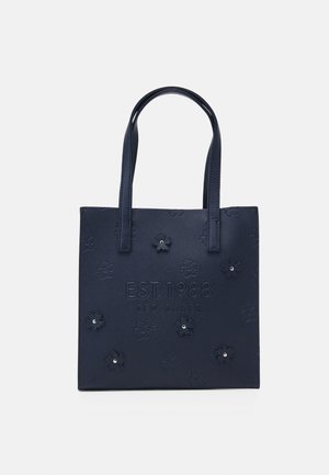 Sac fourre-tout carré bleu marine avec double poignées, motifs floraux en relief et texte "EST. 1988 TED BAKER" à l'avant.