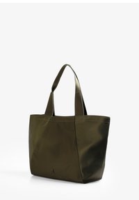 Bolso tote verde oliva hecho de un material suave y duradero, con dos asas resistentes y un logotipo decorativo en la parte inferior. Presenta detalles cosidos.