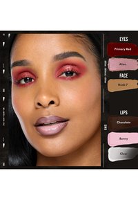 Donna con ombretto rosso lucido, labbra mauve opache e pelle marrone medio liscia su uno sfondo nero con campioni di colore per trucco.