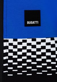 Tessuto blu con un motivo a scacchi bianco e nero. Presenta un'etichetta nera con "BUGATTI" in testo bianco. Dettaglio della cerniera visibile sul lato.