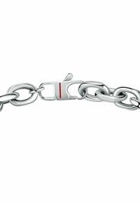 Bracciale in argento con grandi anelli ovali e un fermo con un dettaglio a striscia rossa, che presenta una finitura metallica lucida e una texture liscia.