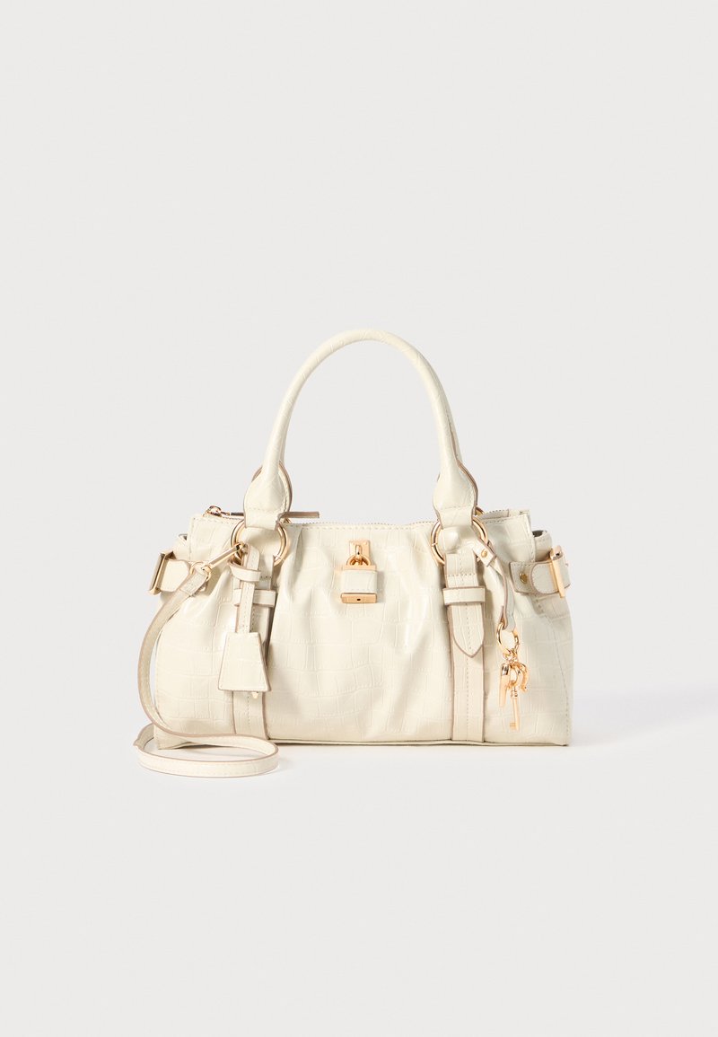 Hvit preget lær handbag med en strukturert form, doble topphåndtak og hardware i gulltone. Har justerbar skulderrem og nøkkelcharmer.
