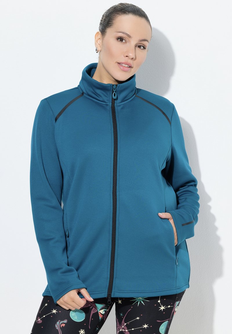 Tyrkysová fleecová bunda s vysokým límcem, černým zipem a akcenty na ramenou; obsahuje kapsy na zip a hladkou texturu.