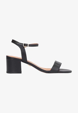 Sandale à talons en cuir noir avec un embout carré, une bride de cheville et un talon bloc. Texture lisse avec un design minimaliste et une accent en boucle métallique.