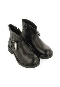 Botines negros de cuero texturizado con punta redonda, cremalleras laterales y una correa con un detalle de hebilla plateada. Tacón bajo y apilado.